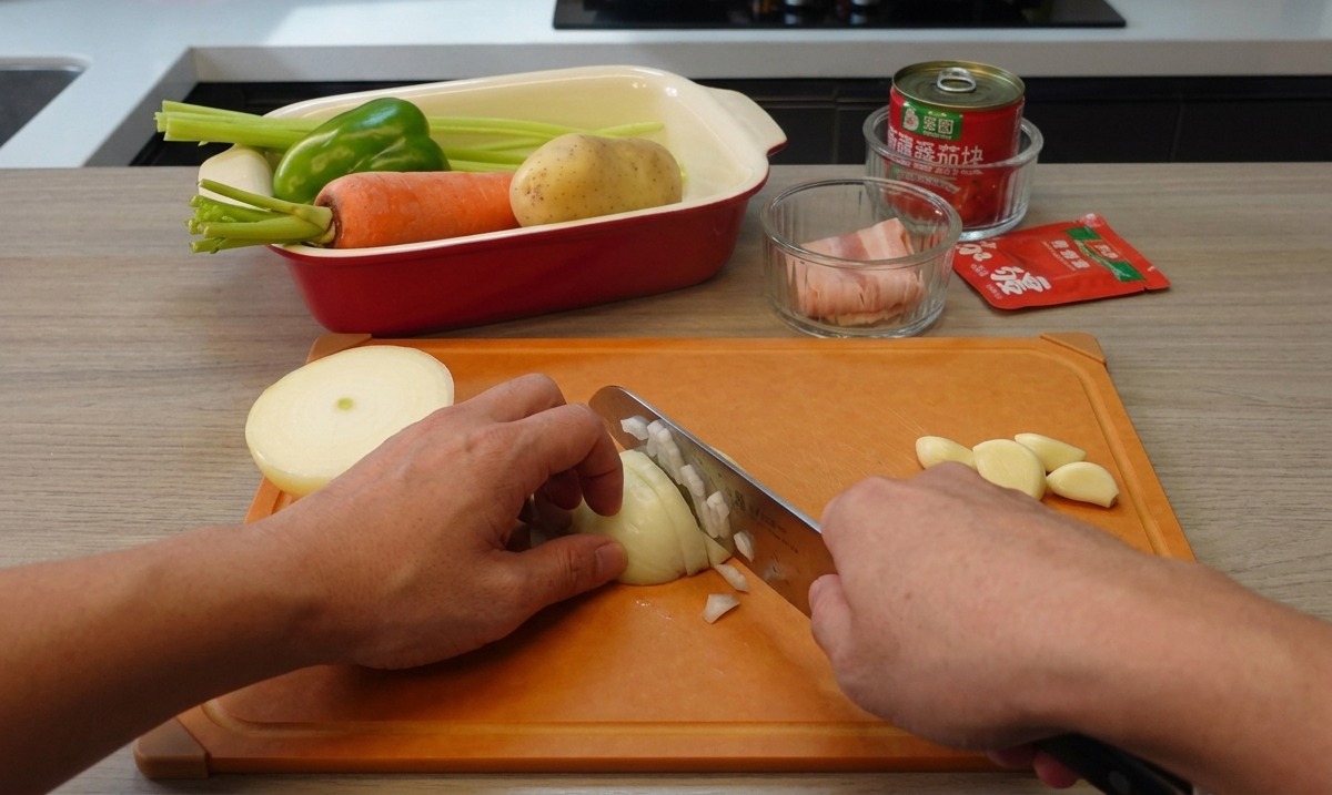 Two hands holding a kitchen knife and finely dicing a white onion on an orange cutting board, with garlic cloves nearby.