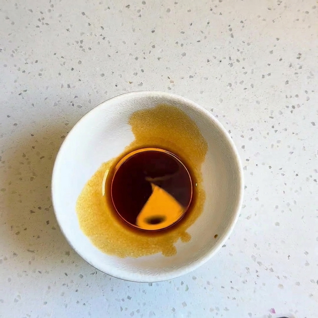 A small white bowl containing a dark, well-mixed liquid stir-fry sauce.