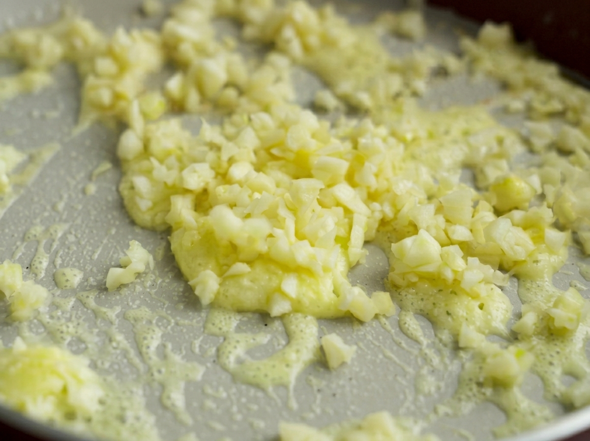 Finely minced pieces of garlic cooking gently in a bubbly melted butter and cornstarch base.