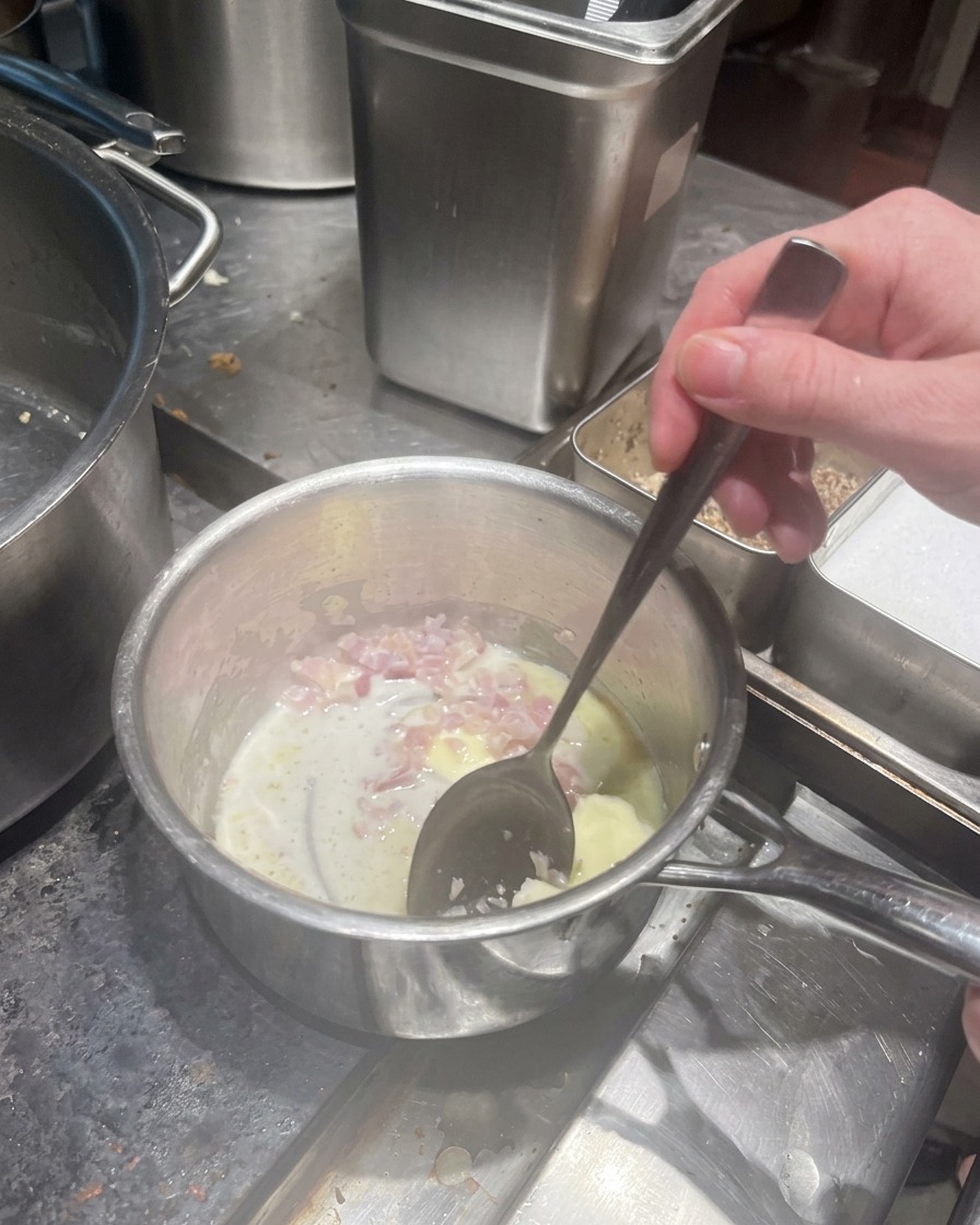 Diced shallots cooking in melted butter in a metal saucepan.