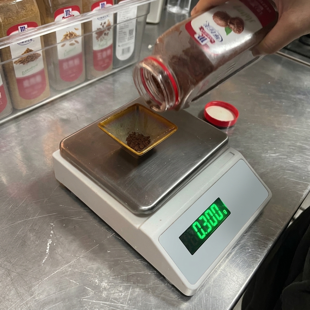 A person pouring brown ground nutmeg from a spice bottle into a small square dish on a digital scale displaying 0.300.