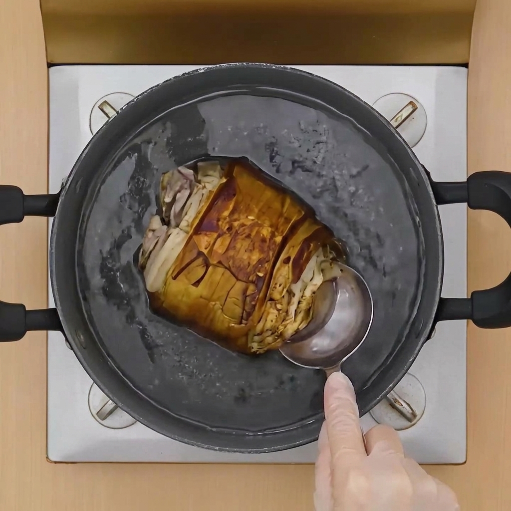 A metal ladle pouring liquid over a browned, tied pork belly roll sitting in a pot of simmering broth.