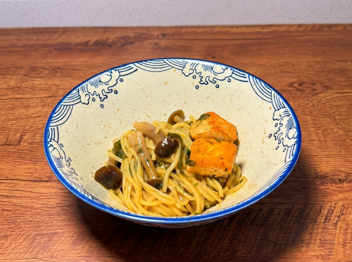 A beautifully arranged ceramic bowl containing cooked ramen noodles topped with pan-fried salmon chunks and mushrooms, resting on a wooden surface.