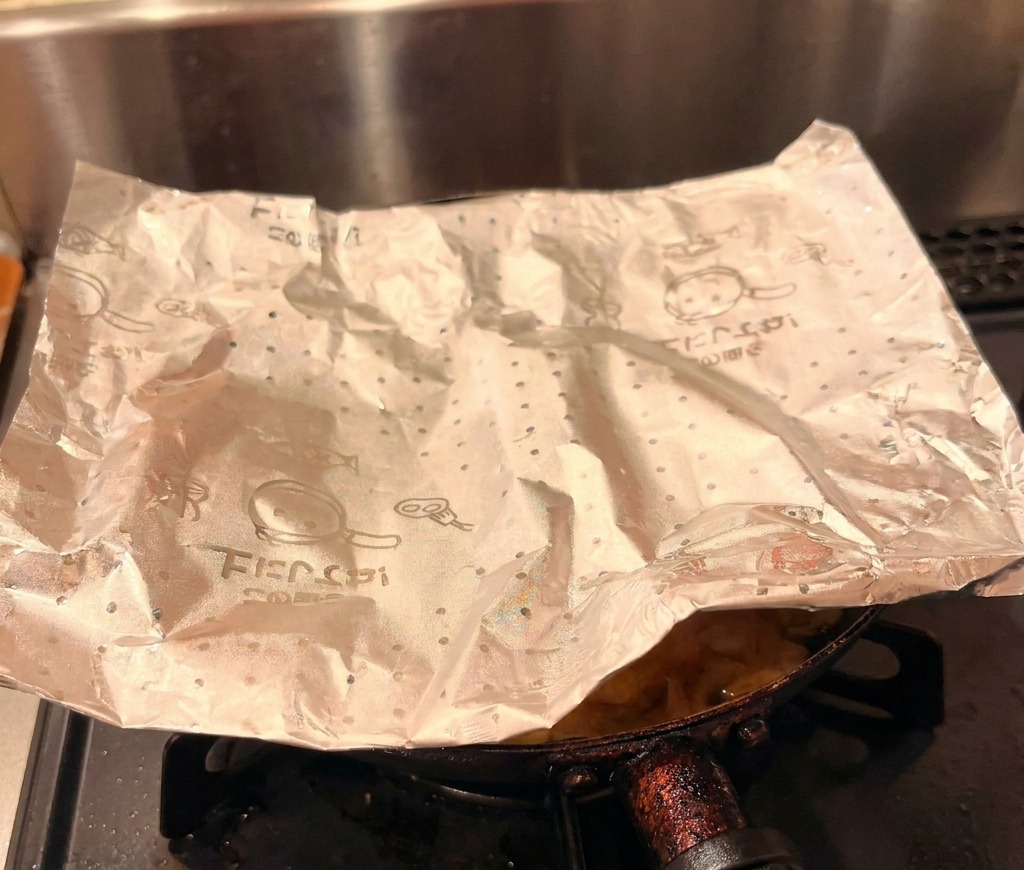 The finished chicken and egg topping being carefully slid from a pan onto a bowl of white rice.