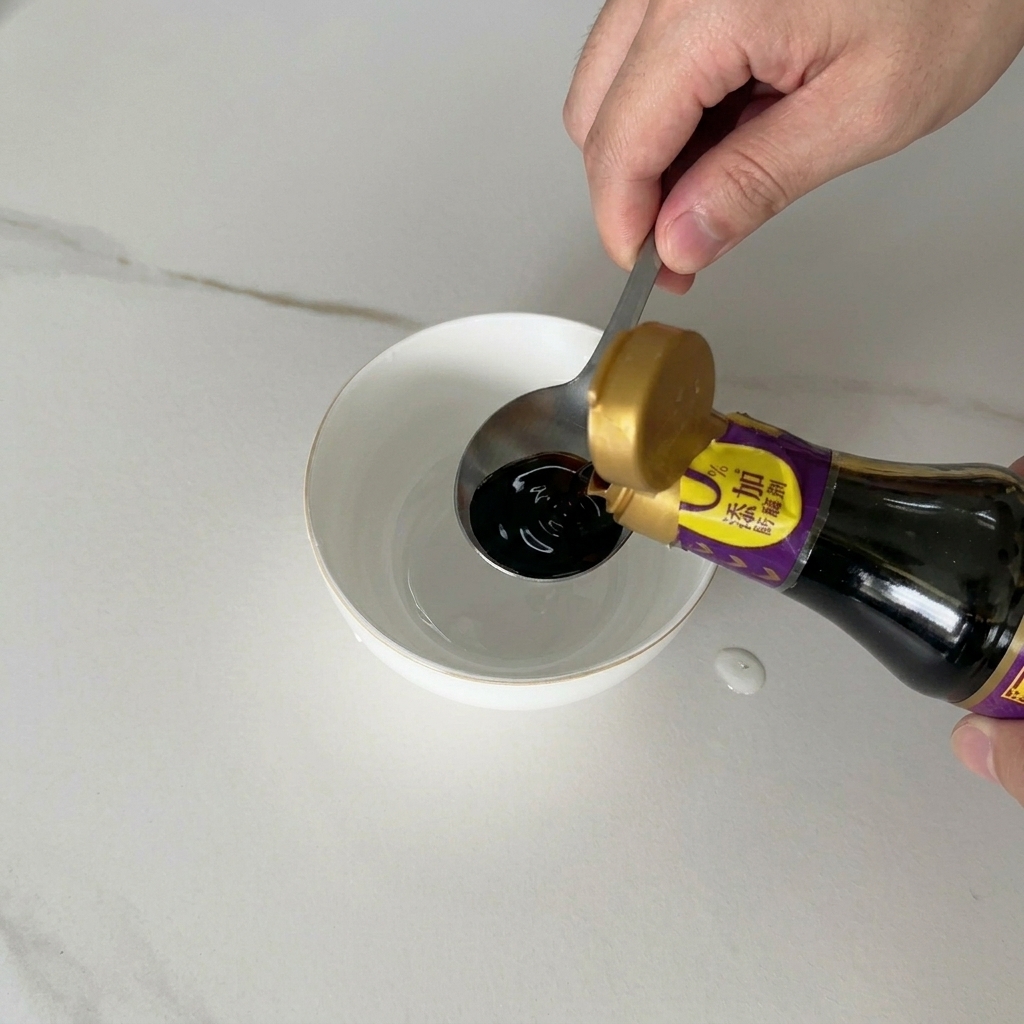 Dark soy sauce being poured from a bottle into a small white ceramic bowl containing other liquid ingredients.