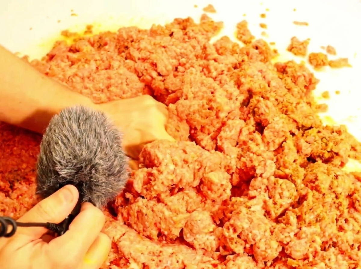 A spoon lifting a small portion of the finished sloppy joe filling.