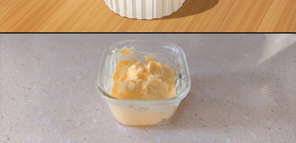 A small square glass container holding mixed yellow mustard butter.