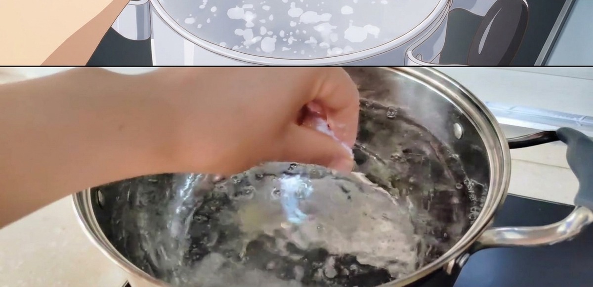 A hand dropping a pinch of salt into a pot of actively boiling water.