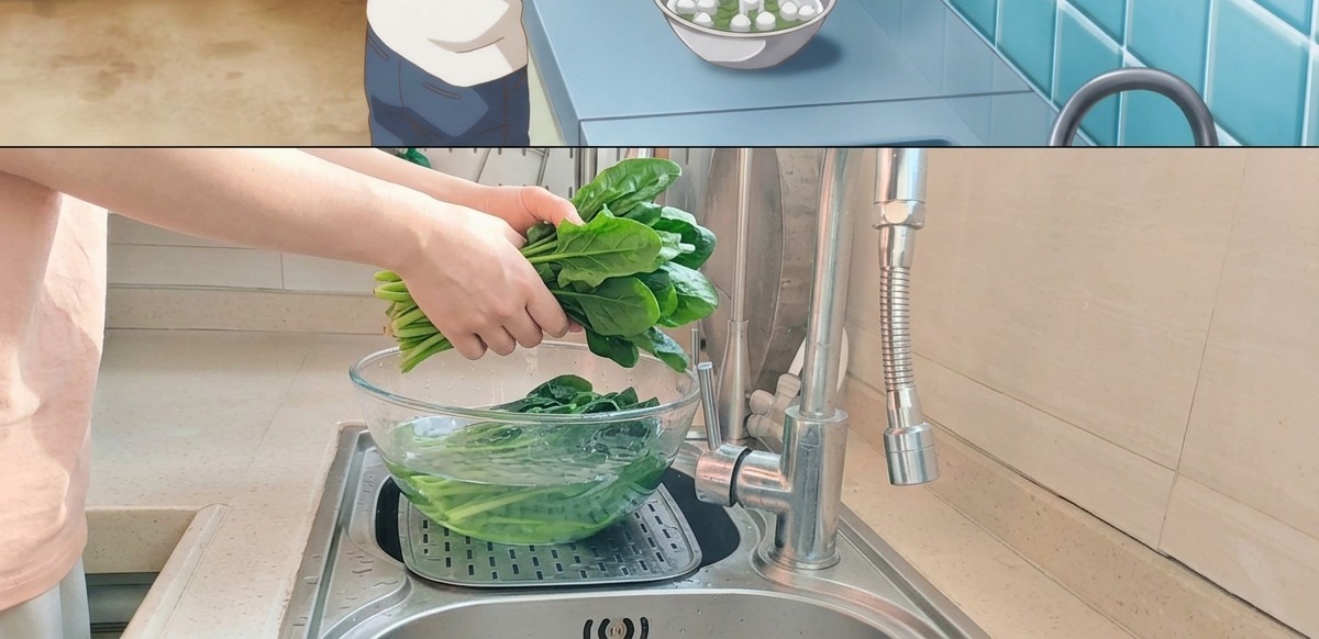 Blanched green spinach being placed into a glass bowl filled with cold water in a sink.