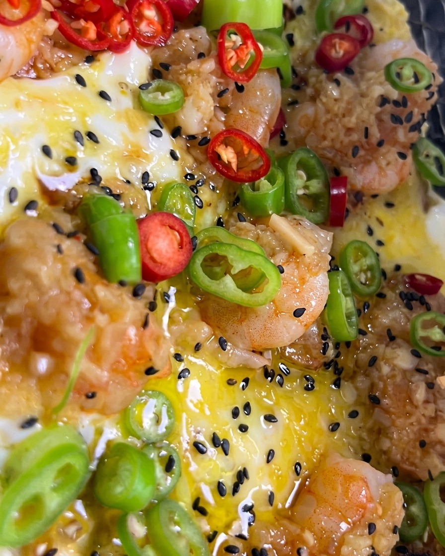 Zigzag lines of white salad dressing and black sesame seeds being applied to a pizza on a grill.