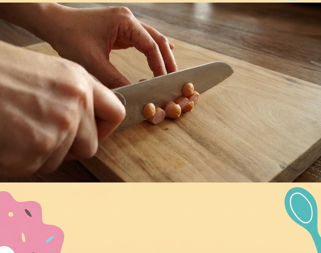 A close-up of a knife slicing small pink sausages into thin circular pieces on a light wooden cutting board.