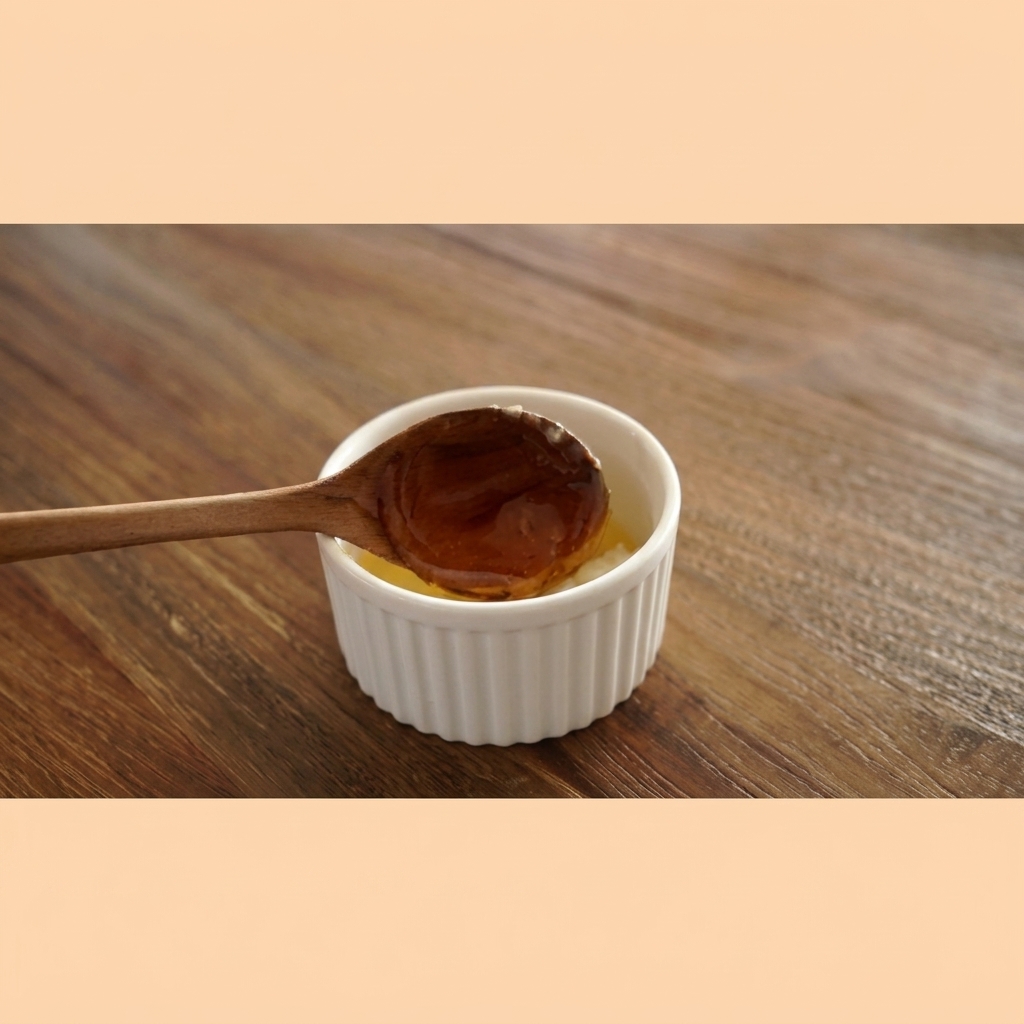 Amber-colored honey thicky dripping from a wooden spoon into a white bowl of garlic butter.