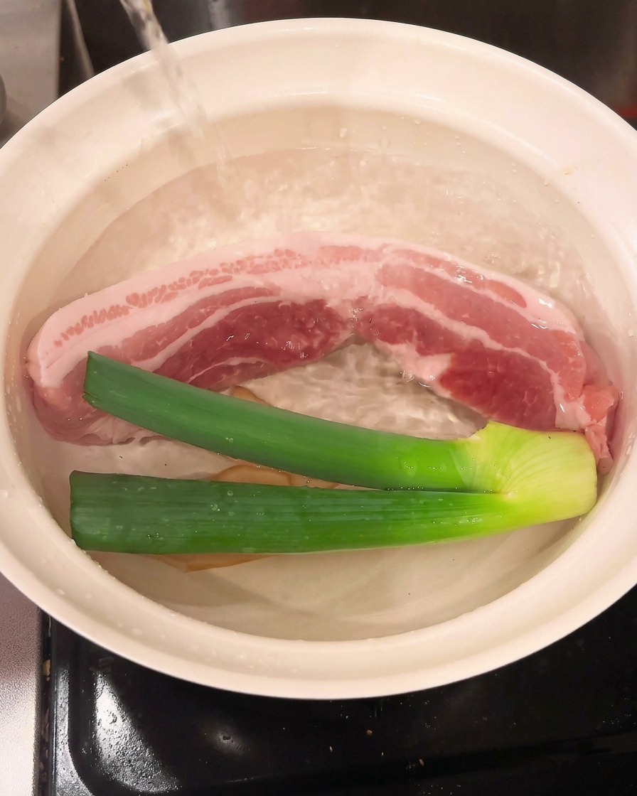 Cooking wine being poured into the pot, combining with the pork and aromatics.