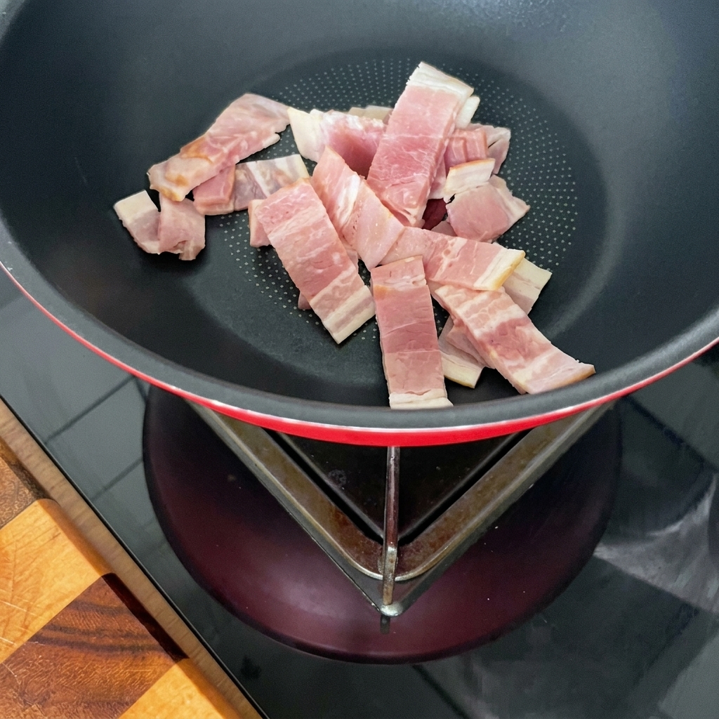 Bacon strips and sliced mushrooms cooking and browning together in a skillet.
