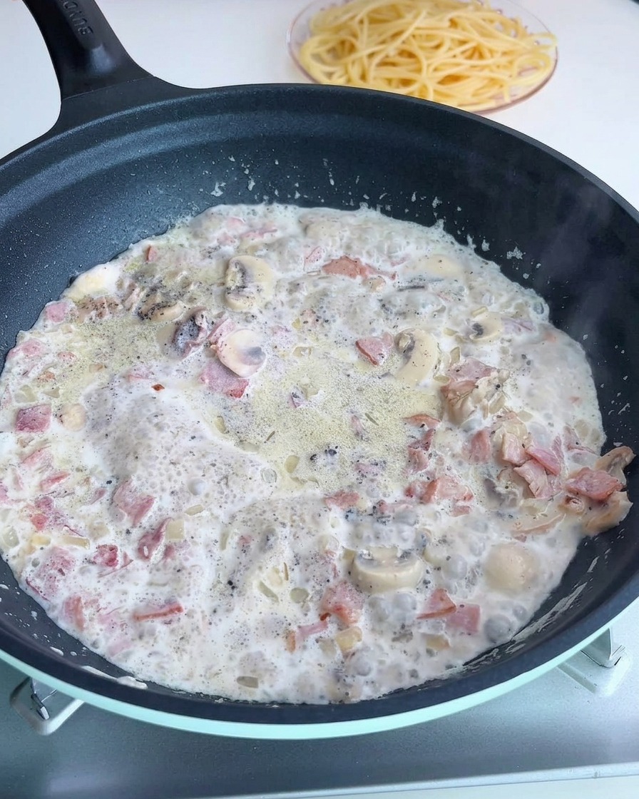 Seasoning the creamy sauce in the pan with salt and pepper.