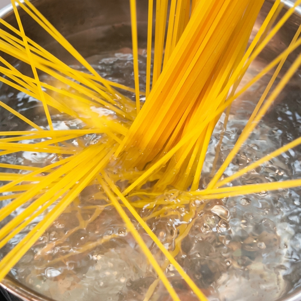 Spaghetti noodles cooking in a large pot of boiling salted water.