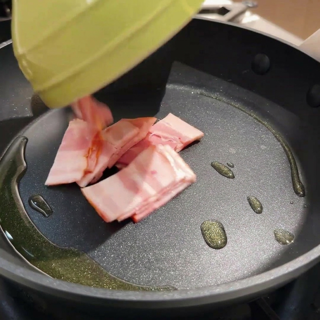 Crispy bacon pieces frying in a hot pan with oil.