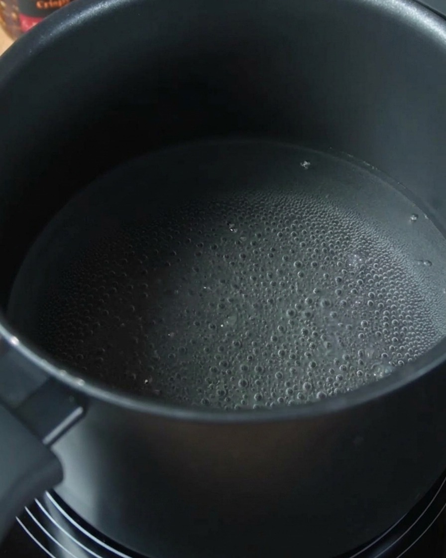 Spaghetti noodles softening in a pot of boiling water.