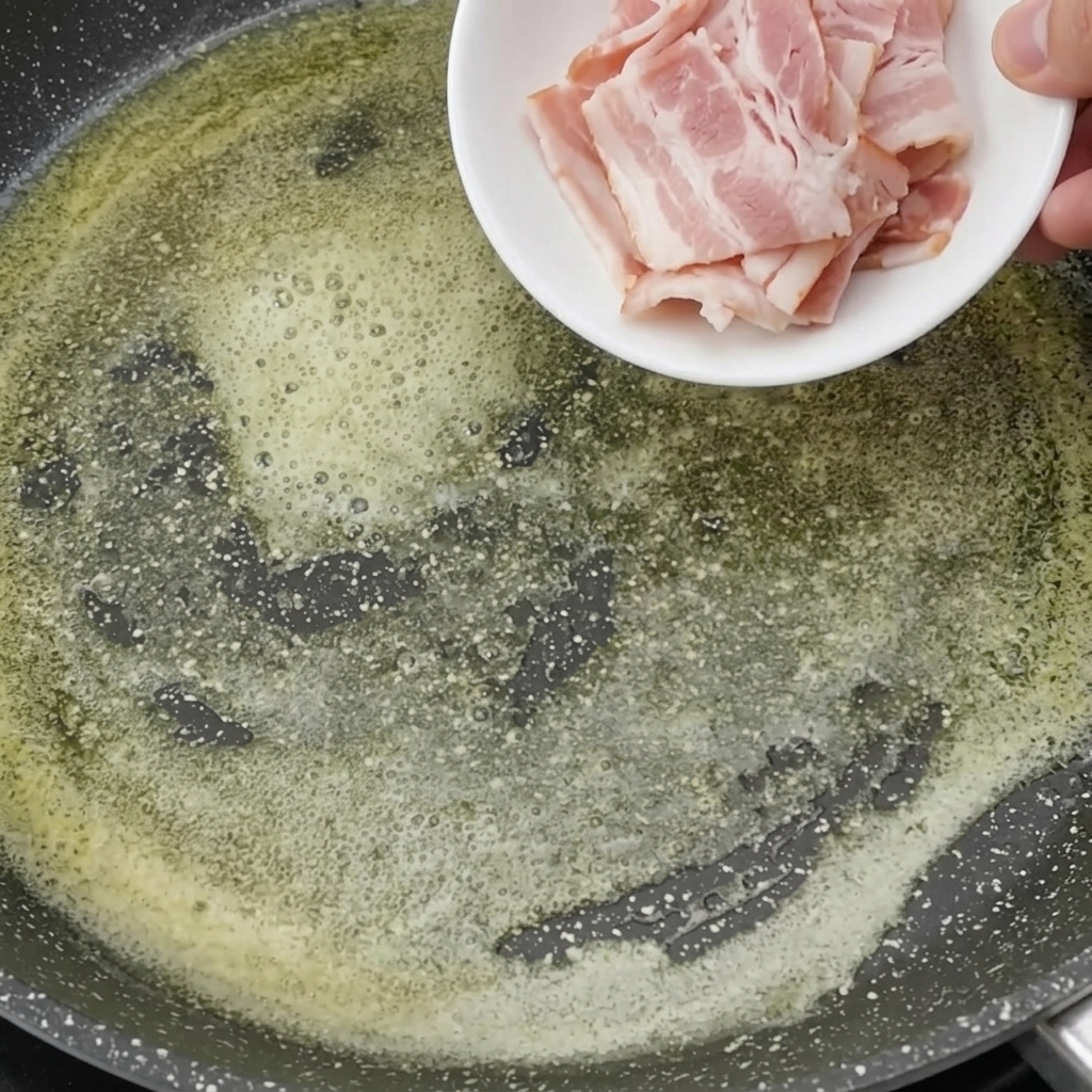 Bacon pieces frying in melted butter until crispy and golden brown.
