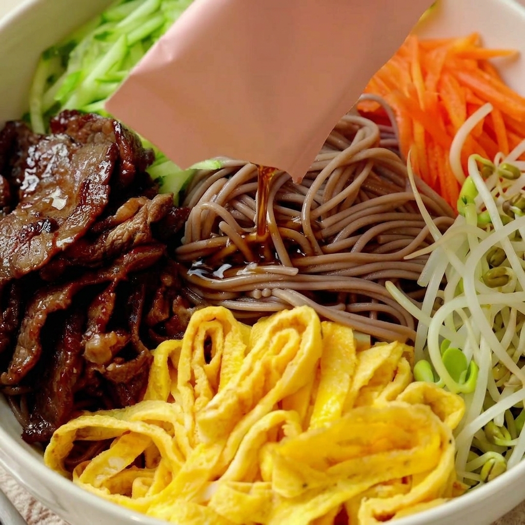 Yuzu ponzu sauce being poured from a packet over the prepared noodle bowl.