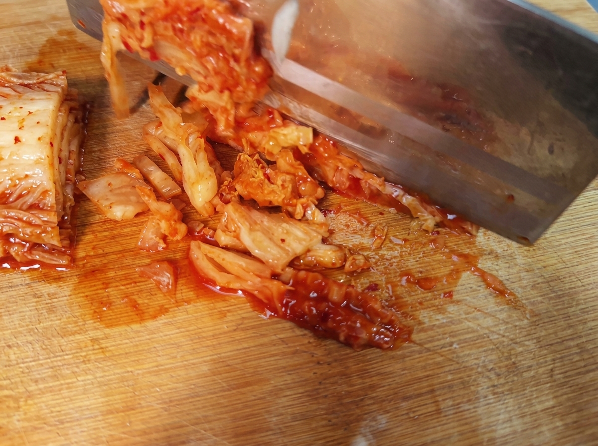 Slices of spicy Korean kimchi laid out on a cutting board.