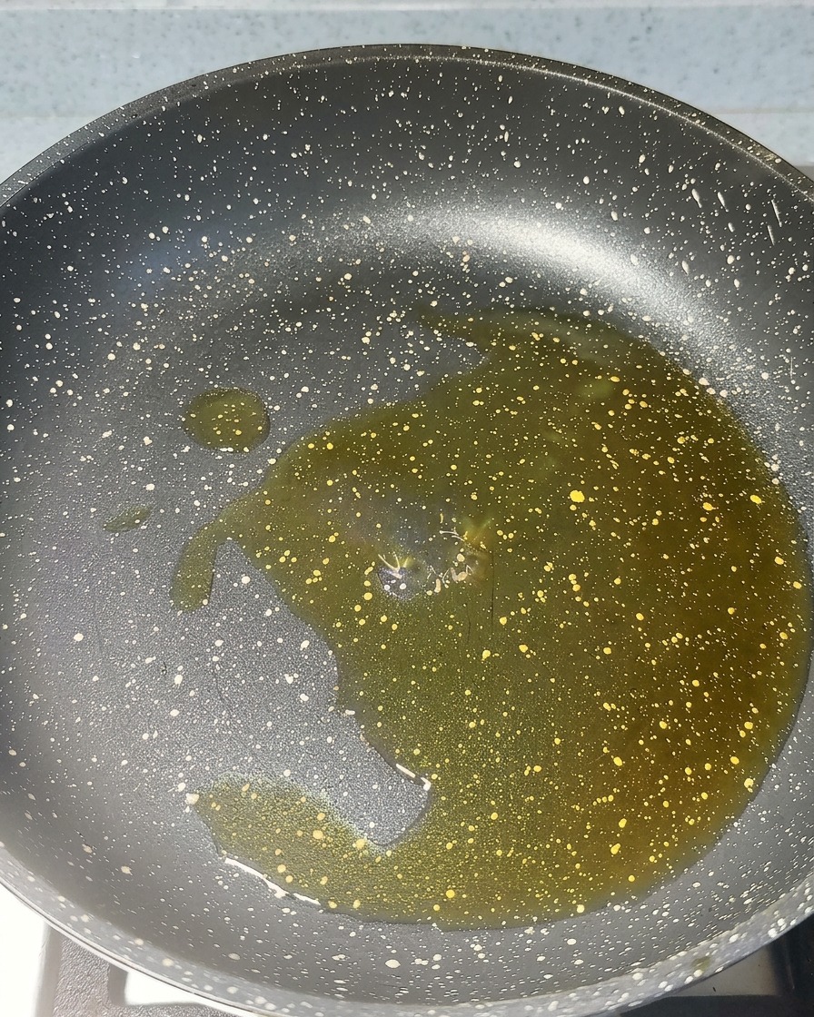 Minced garlic and red shrimp paste sizzling in hot oil in a pan.