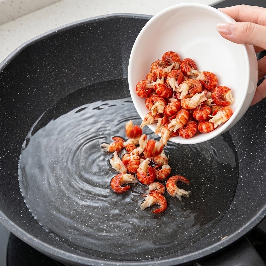 Crawfish tails being blanched in a pot of boiling water with aromatics.