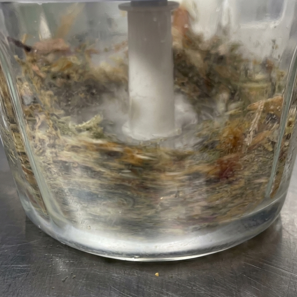 Adding the fine fish powder into the liquid sauce base in the metal pot.
