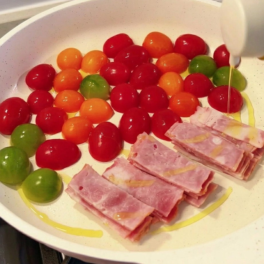 The pan filled with carefully arranged sections of enoki mushrooms, slices of pink spam, and firm white tofu blocks.