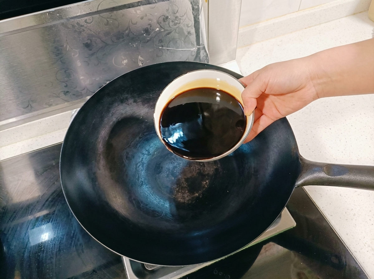 A mix of soy sauce and aromatic spices simmering in a wok over a stove.