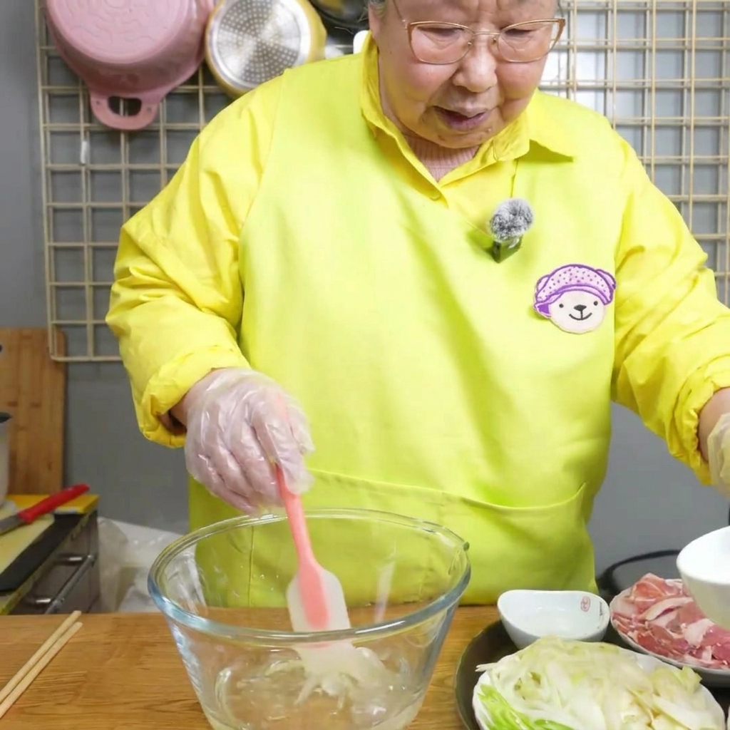 Clear soy sauce being poured into an empty glass mixing bowl.