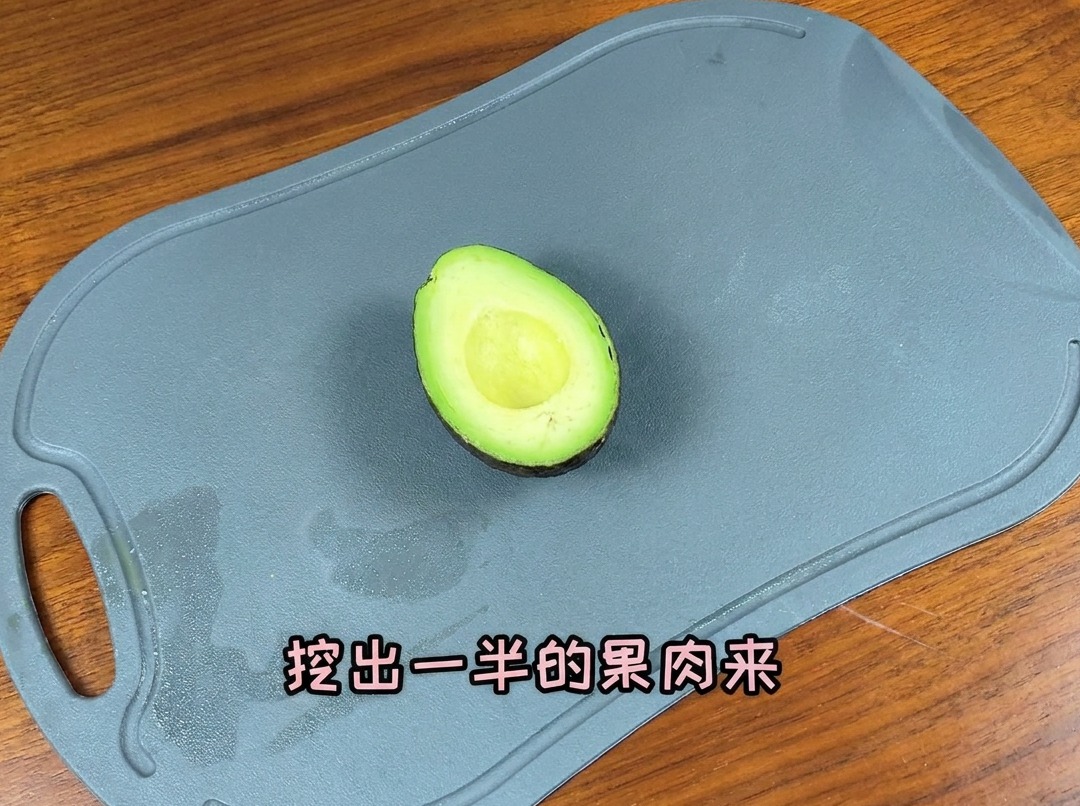 A halved avocado on a cutting board, ready to be sliced for the burger filling.