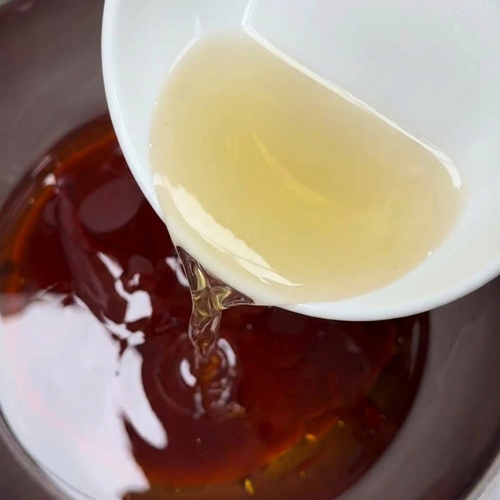 Rice vinegar being poured into the sauce bowl.
