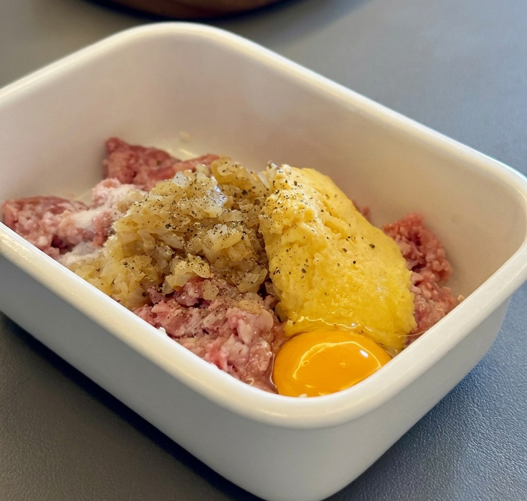 Ingredients for the Hamburg steak patties combined in a white container.