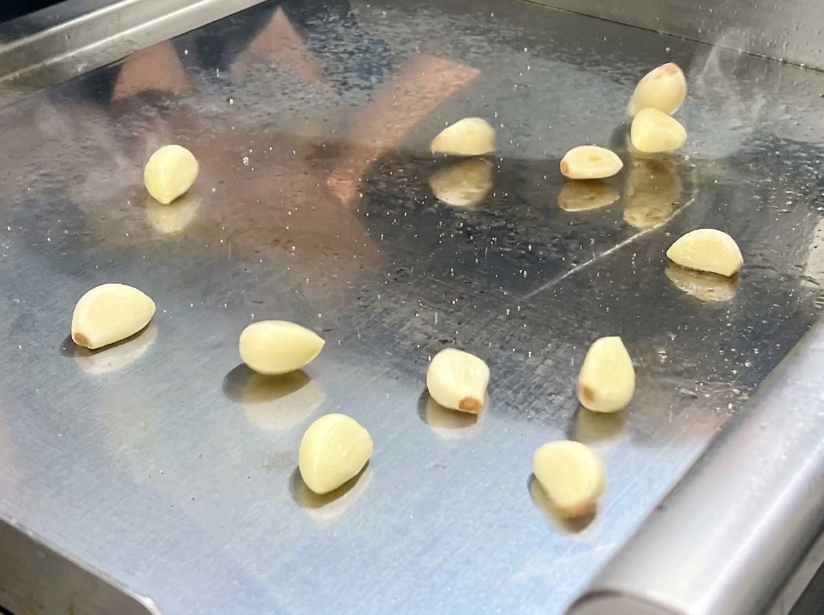 The stir-fried pepper and aromatic mixture being scooped into a food processor bowl.