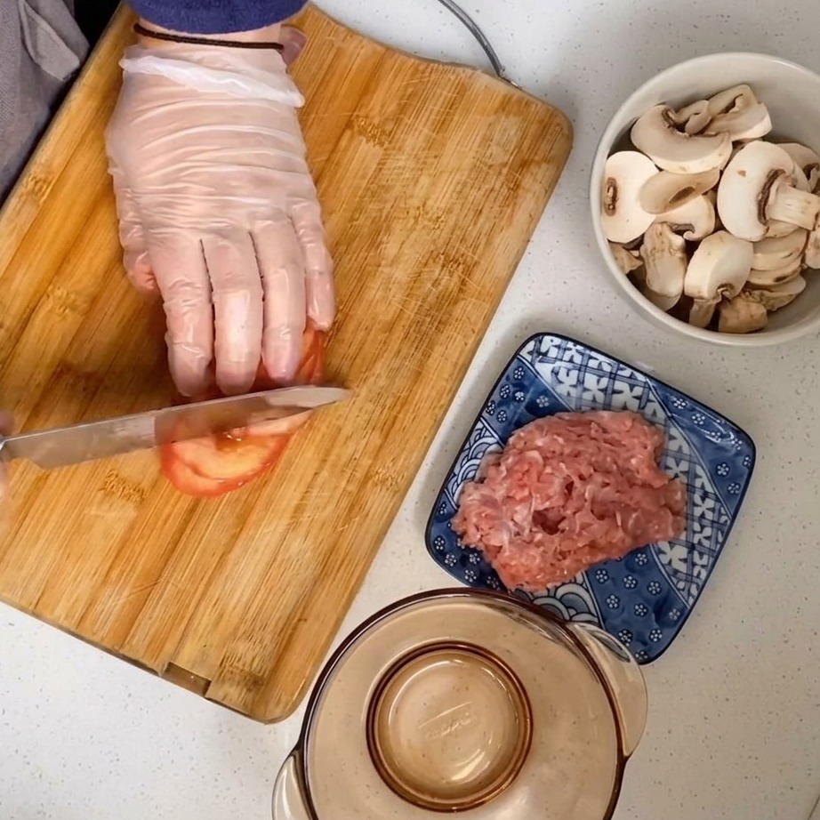 A peeled tomato being diced on a wooden cutting board.