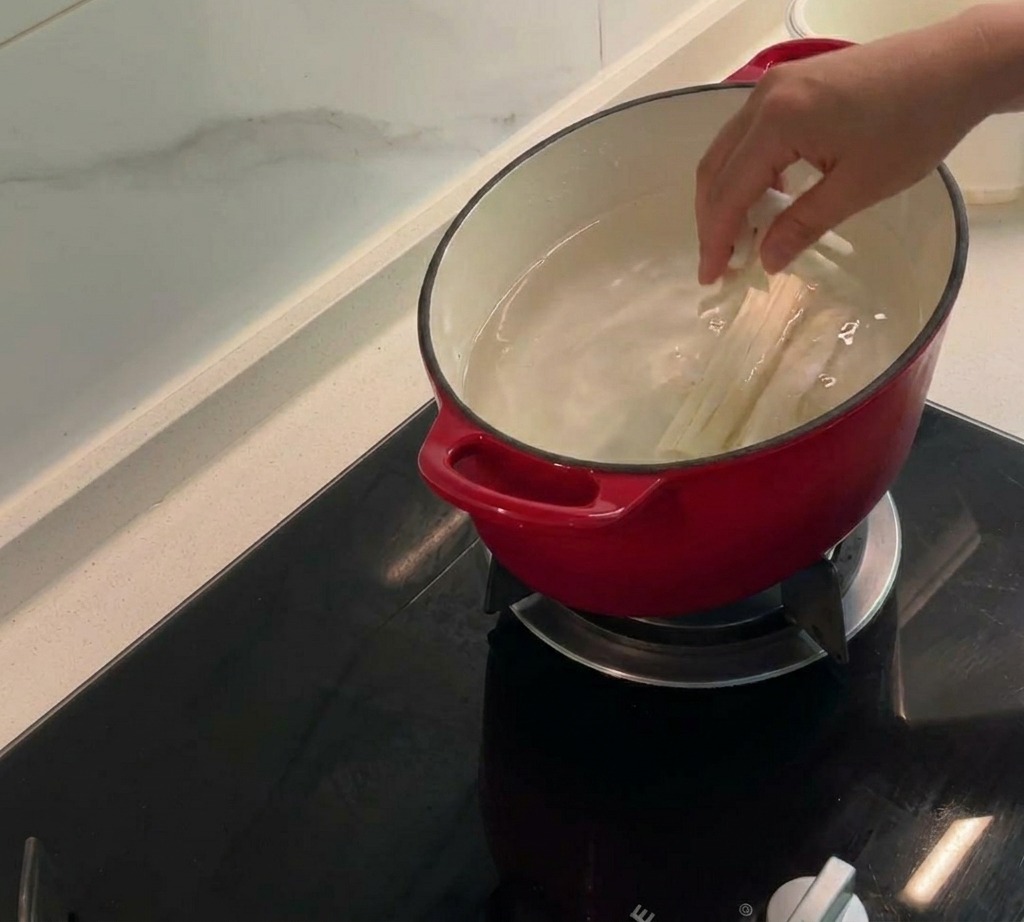 Corn silk, cobs, and chicken skins simmering in a pot of water to create a savory stock.