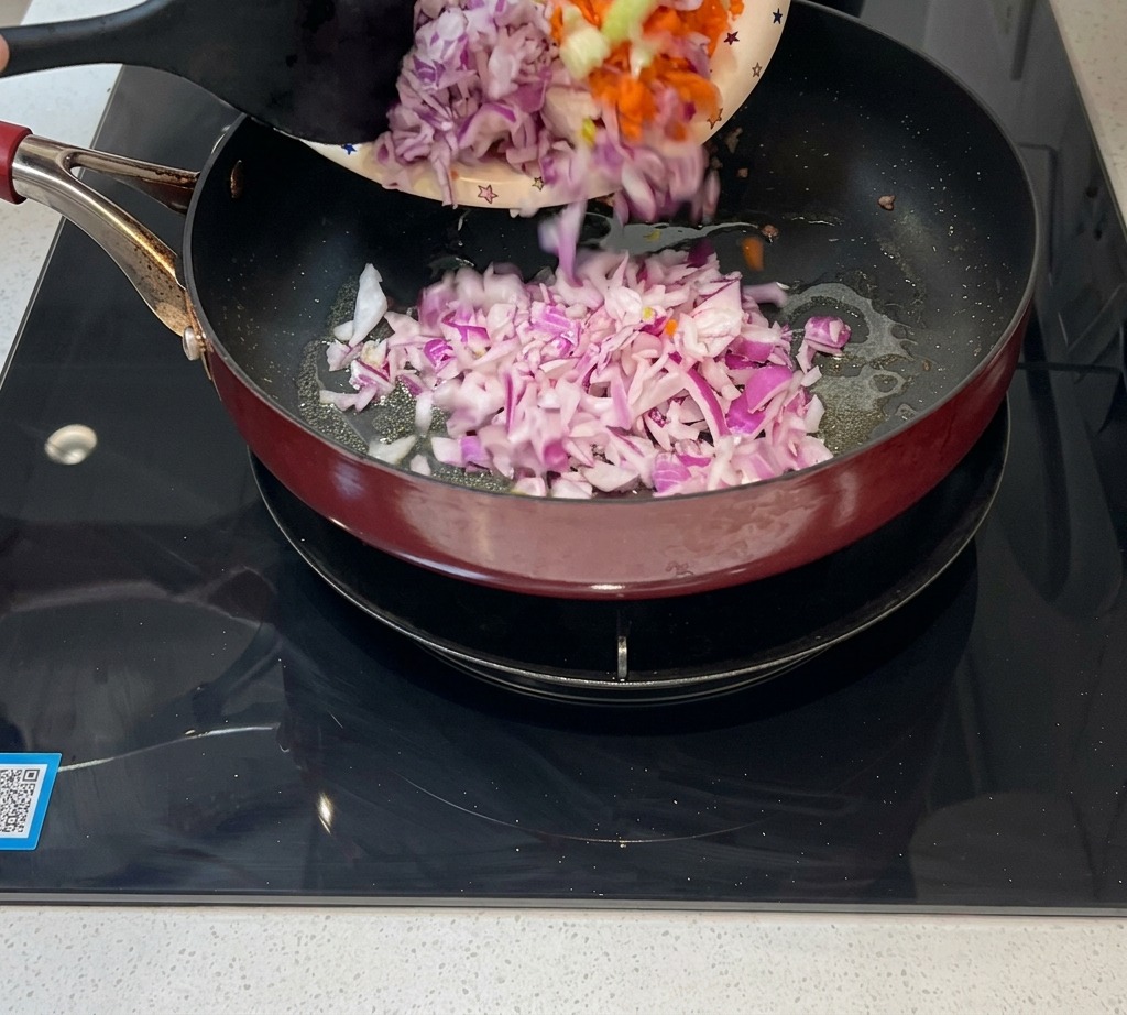 Finely diced onions, carrots, and celery being poured into a pan to be sautéed.