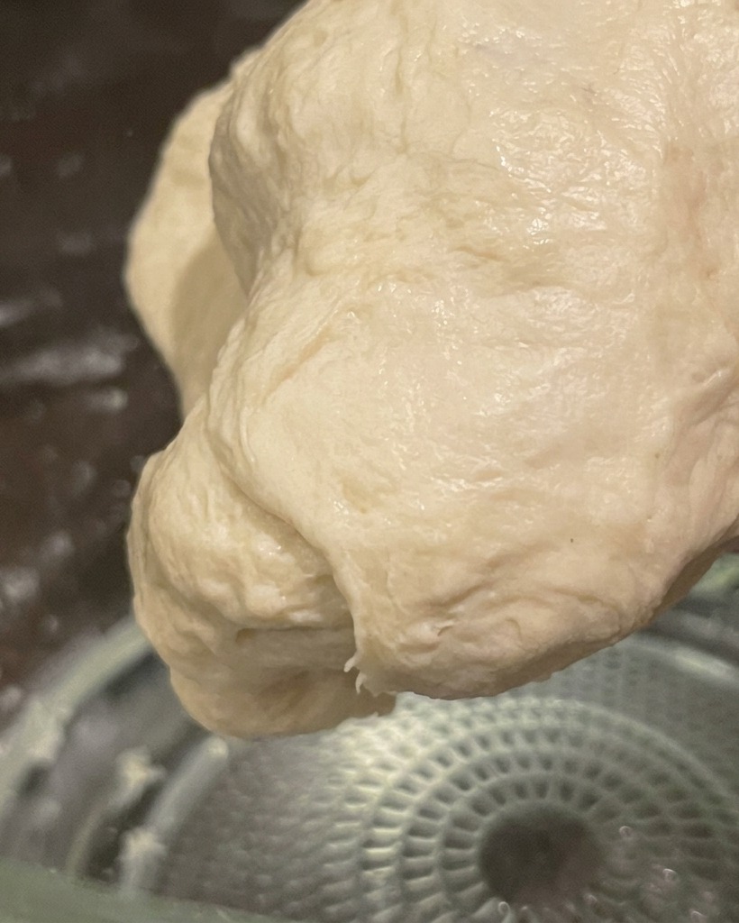 A smooth, elastic ball of hand-kneaded dough held in preparation for fermentation.