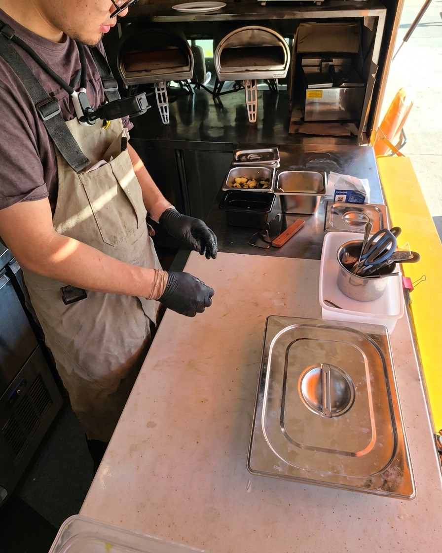 Dough ball being pressed flat into a disc on a floured surface.