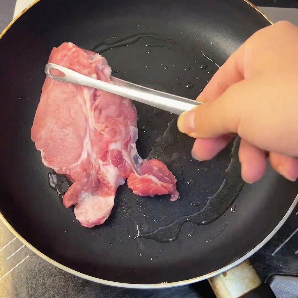 A raw egg yolk, minced garlic, and seasoning being whisked in a bowl.