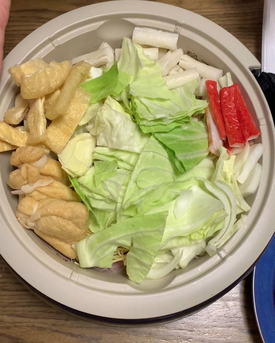Thin carrot slices added to the pot among the other prepared ramen ingredients.
