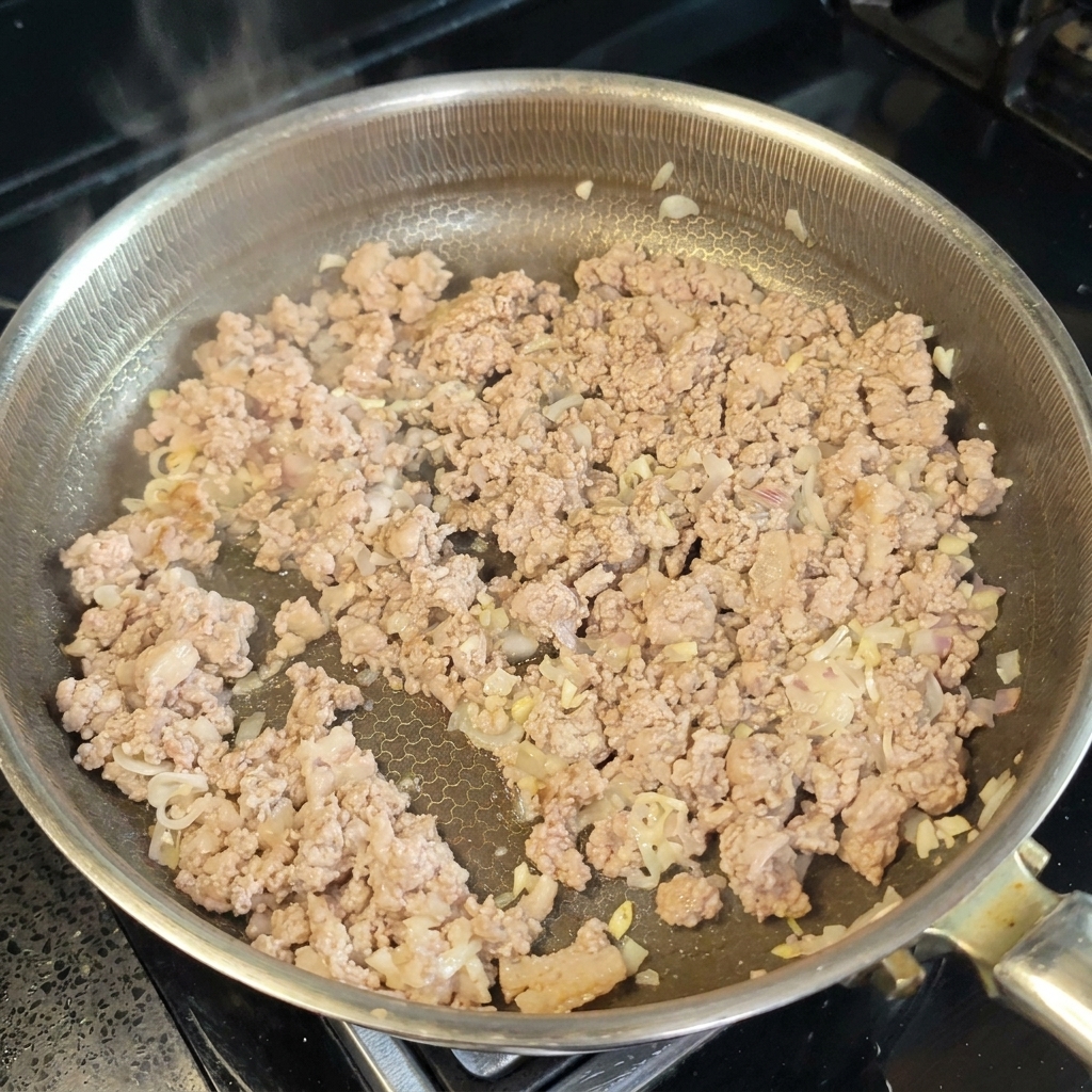 Cooking wine and miso paste being stirred into the cooked meat.