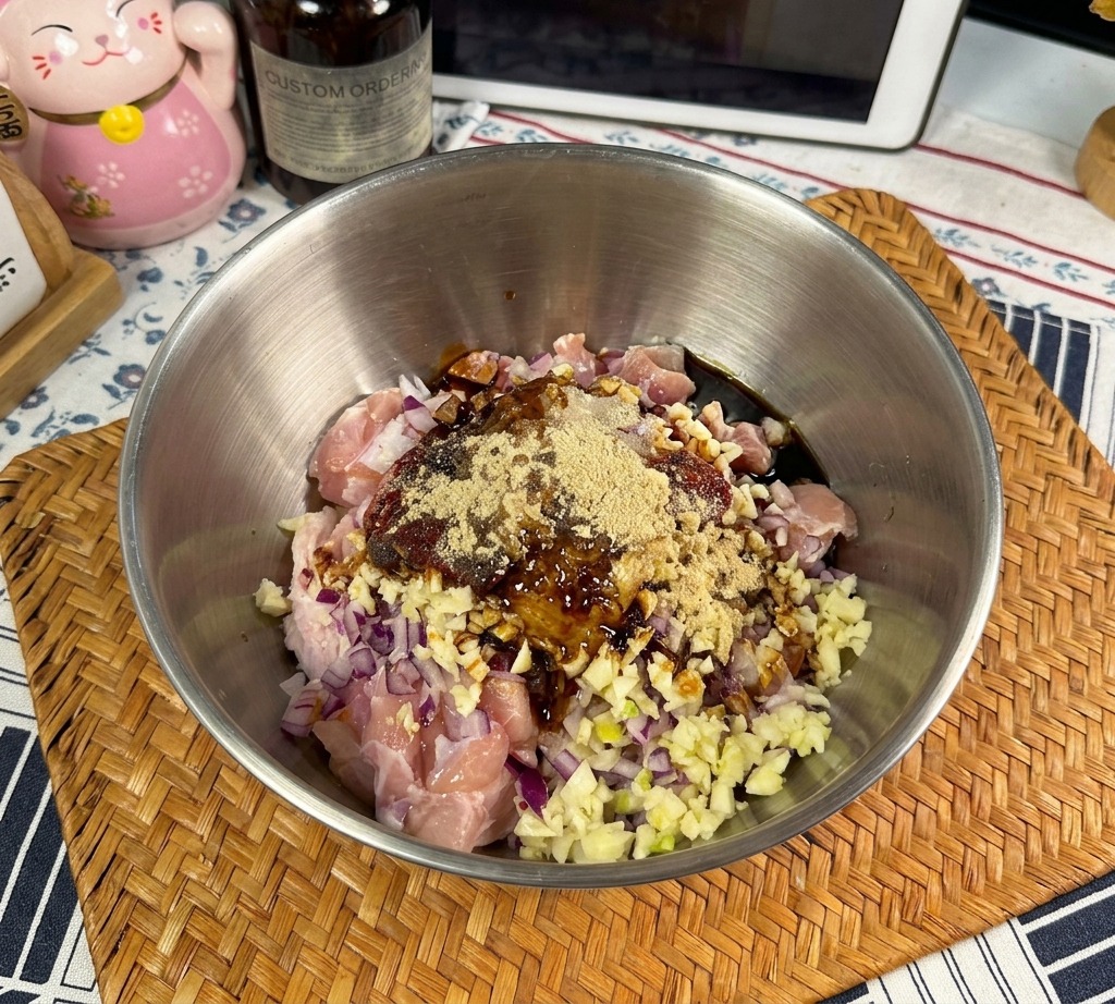 Dark, thick oyster sauce being poured from a bottle into a bowl of marinated chicken and spices.