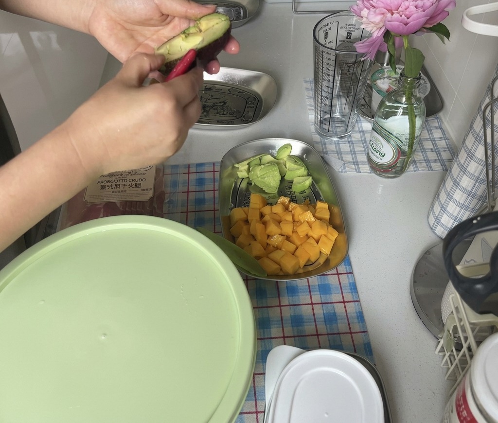 Hands twisting open a dark skinned ripe avocado to access the fruit