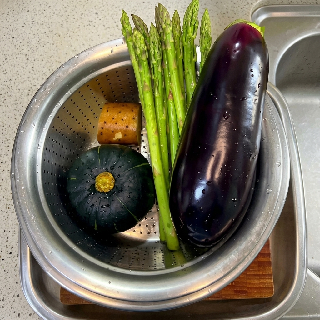 Freshly washed and sliced asparagus, eggplant, and pumpkin pieces arranged on a cutting board.