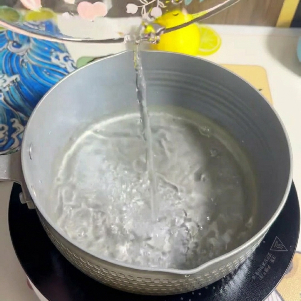Milk being poured into the pot, mixing with the water.