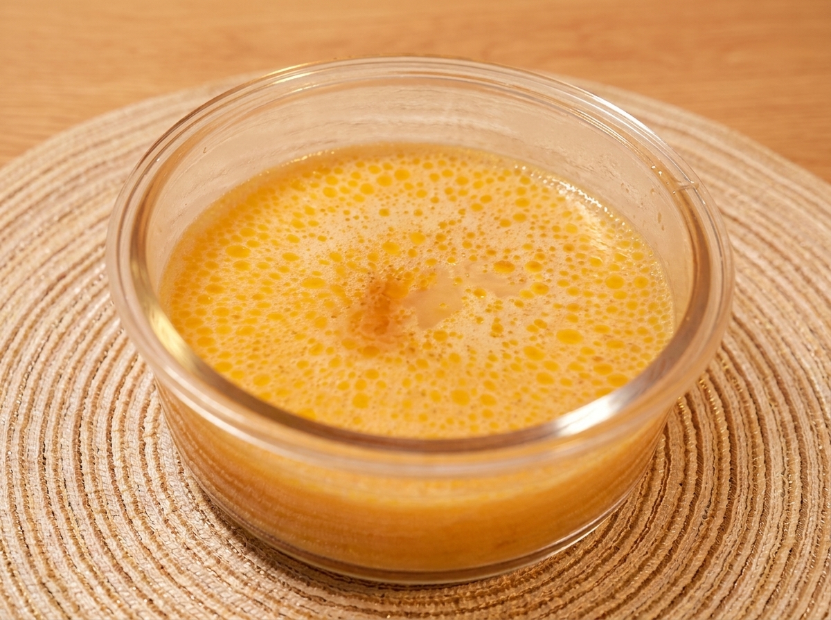 Miso paste, sugar, and mirin being whisked into a pot of rich bone broth.