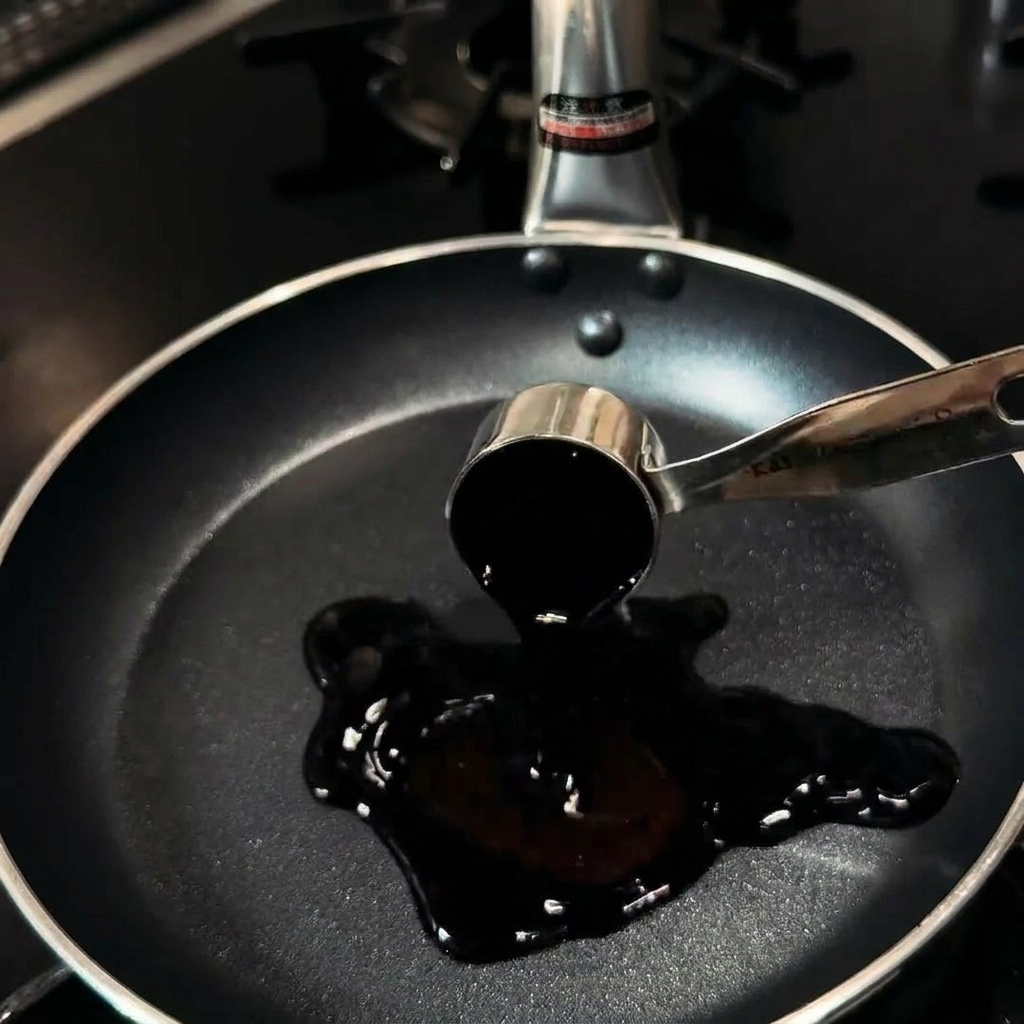 Soy sauce, mirin, sugar, dashi, and water being poured into a frying pan.
