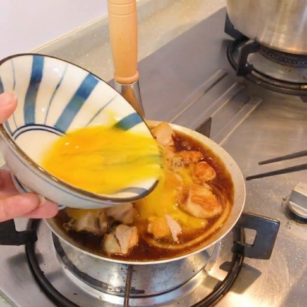 A finished Oyakodon-style dish in a skillet, garnished with fresh green onions.
